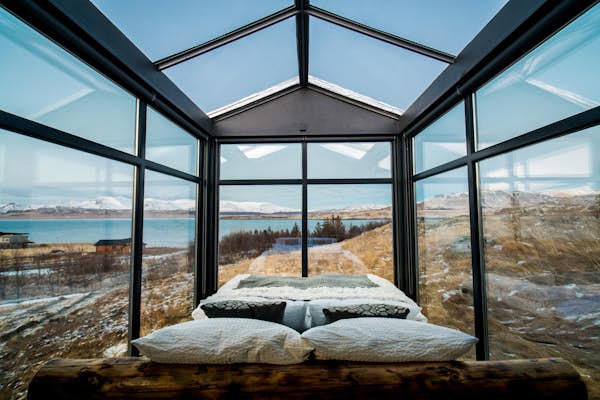 Panoramic glass lodge room example with wide landscape view through full glass walls