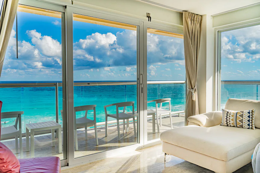 Panoramic ocean view room example showing wide glass doors and balcony